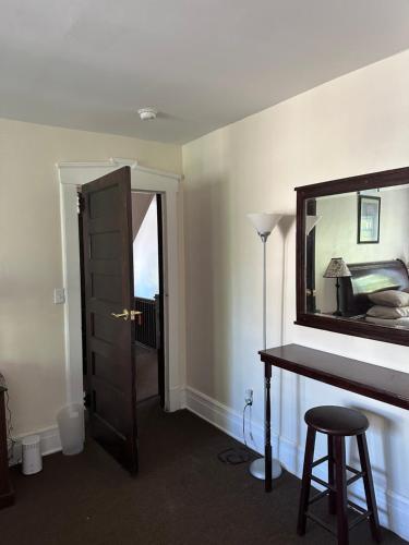 Habitación con escritorio y espejo en la pared. en Victorian Palace- Mahogany Room, en East Orange