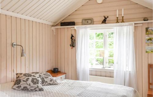 een slaapkamer met een bed en een raam bij Cozy Home In Henn With Kitchen in Henån
