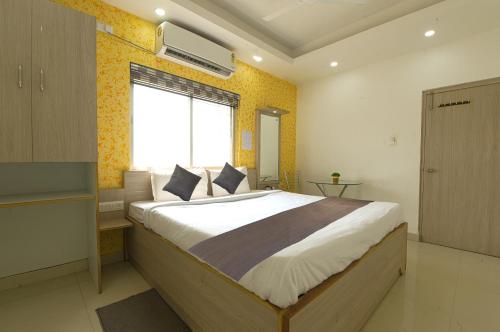 Kama o mga kama sa kuwarto sa Aura Hotel Rajdhani Residency
