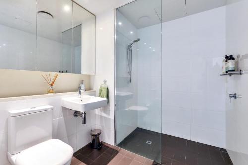 a bathroom with a shower and a toilet and a sink at Cute & Cosy Darwin Waterfront Apartment with Queen Bed in Darwin
