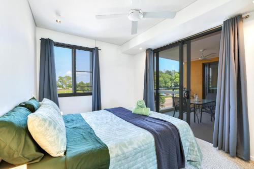 a bedroom with a bed and a large window at Cute & Cosy Darwin Waterfront Apartment with Queen Bed in Darwin