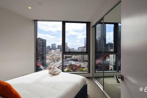 een slaapkamer met een bed en een groot raam bij Southbank 23F 1BR 4Guest City Skyline Pool & Gym in Melbourne