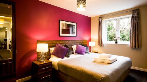 a bedroom with a bed with purple walls and a window at SOUTHAMPTON Central Apartments - Wise Stays in Southampton