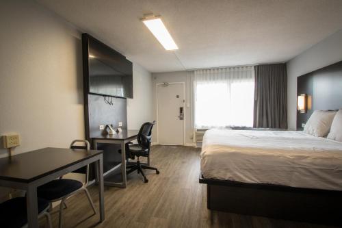 a hotel room with a bed and a desk and a desk at Envi Boutique Hotel Henderson-Evansville South in Henderson