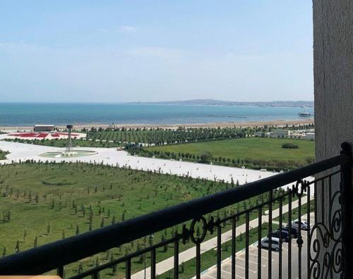 a balcony with a view of a field and the ocean at Boulevard in Sumqayyt