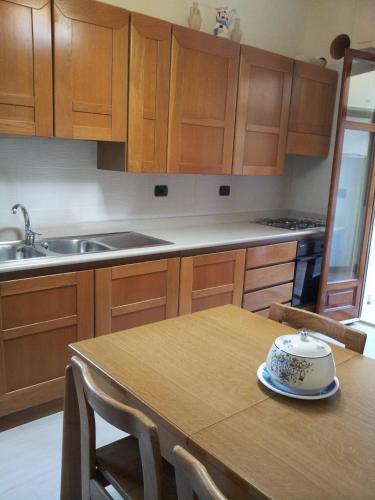 a kitchen with wooden cabinets and a wooden table at Le Giarette in Cefalù