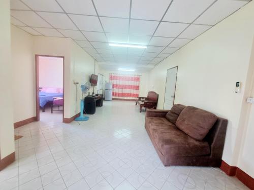 a living room with a brown couch in a room at Mae Rampung Beach House คาราโอเกะและสระเด็ก in Rayong