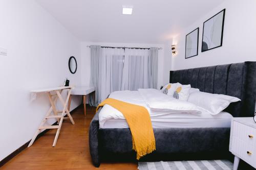 a bedroom with a large bed and a desk at Ruaka Radiance 2-Bed Escape in Ruaka