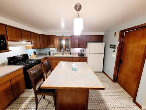 cocina con mesa de madera y nevera blanca en First floor Buffalo/Niagara Apt close to stadium, en Depew