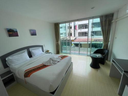 a hotel room with a bed and a large window at Toto Residence in Ao Nang Beach