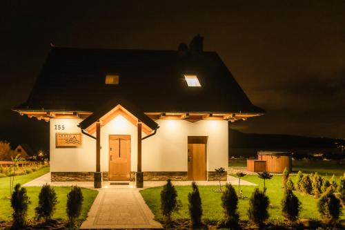 una pequeña casa blanca con una luz encendida por la noche en Chata Stylchyn, en Kluszkowce