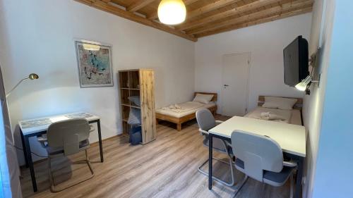 um pequeno quarto com uma mesa e cadeiras e uma cama em Pension Isartal em Geretsried