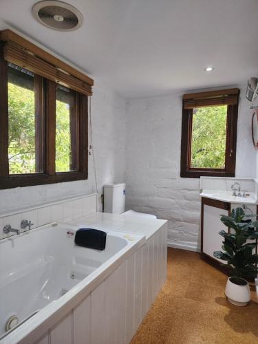 Baño blanco con bañera y lavamanos en Daylesford - FROG HOLLOW ESTATE - The Homestead, en Daylesford