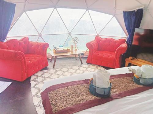 um quarto com duas cadeiras vermelhas e uma mesa em Black Diamond Camping em Khao Kho