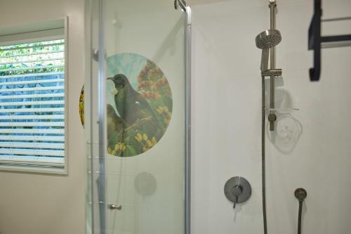a green bird is sitting in a shower at Hot Tub, Great Views, Close to Beach in Kaikoura