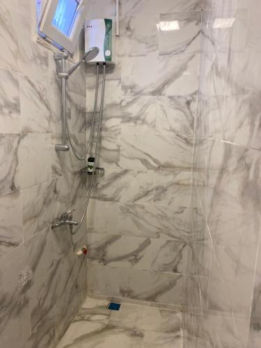 ein Bad mit einer Dusche und weißen Marmorwänden in der Unterkunft yenikapı hotel in Istanbul