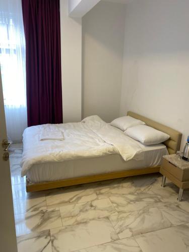 a bed in a bedroom with a marble floor at yenikapı hotel in Istanbul