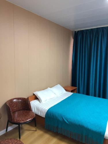 a hotel room with a bed and a chair at Etuga Guesthouse, Close to Sukhbaatar Square in Ulaanbaatar