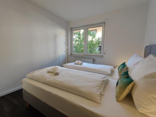 two beds in a room with a window at 85qm, 4 bedroom, parking, King-Bed, Wifi, Netflix in Waiblingen