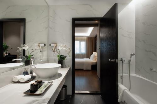 ein Badezimmer mit einem Waschbecken, einer Badewanne und einer Badewanne in der Unterkunft PALAGO BOUTIQUE HOTEL in Hanoi