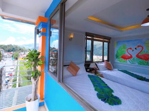 Zimmer mit einem Balkon, einem Bett und einem Fenster in der Unterkunft Bing Sapa Hotel in Sa Pa