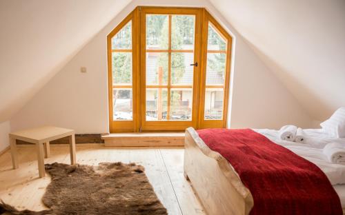 a bedroom with a bed and a large window at Stara Chata w Beskidach in Żabnica
