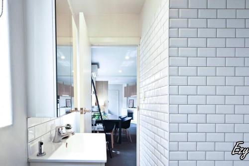 a bathroom with two sinks and a mirror at MCG 1BR Apartment For Family in Melbourne