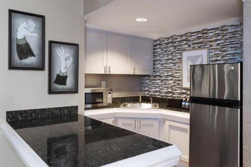 a kitchen with white cabinets and a stainless steel refrigerator at Spartanburg Marriott in Spartanburg