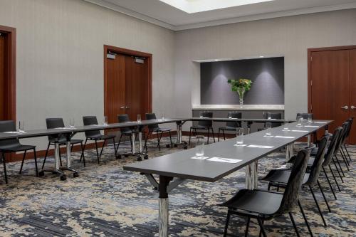 a conference room with tables and chairs and a screen at JW Marriott Grand Rapids in Grand Rapids