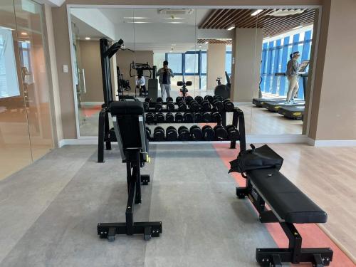 a gym with several treadmills and people in the background at 38 Park Avenue right in the heart of IT Park Cebu, 55 inches TV, wifi in Tabok