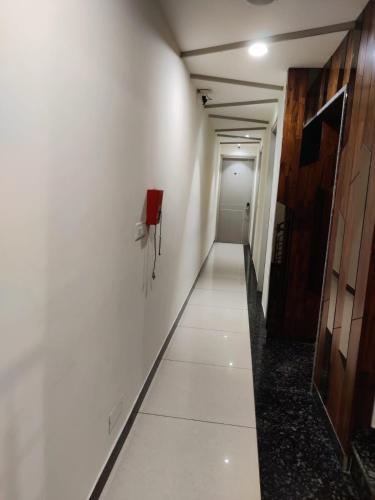 a hallway with white walls and a phone on a wall at Hotel Hamilton in Zirakpur