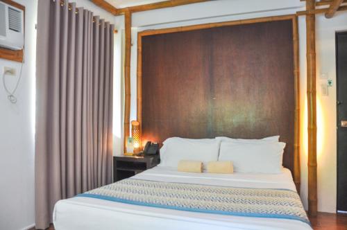 a bedroom with a large bed with a wooden headboard at Acuaverde Beach Resort in San Juan
