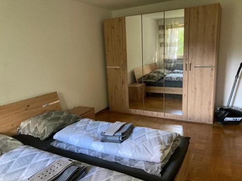 a bedroom with two beds and a large mirror at 2 room apartment with parking in Stuttgart in Stuttgart