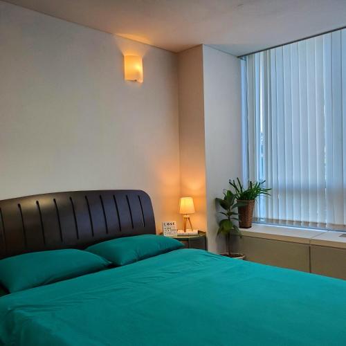 a bedroom with a green bed and a window at Cozy - Warm Studio in Incheon