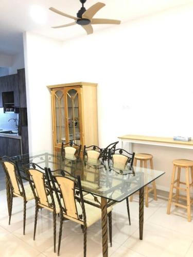 a dining room table with chairs and a ceiling fan at Homestay 7-12pax in Shah Alam in Shah Alam