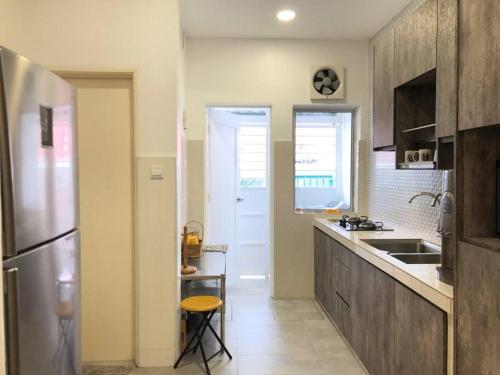 a kitchen with a stainless steel refrigerator and a sink at Homestay 7-12pax in Shah Alam in Shah Alam