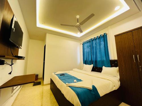 a bedroom with a large bed with a ceiling fan at WELCOME VISTA in Navi Mumbai