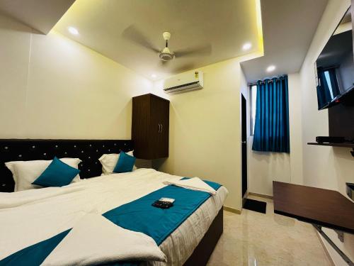 a bedroom with a large bed with blue pillows at WELCOME VISTA in Navi Mumbai