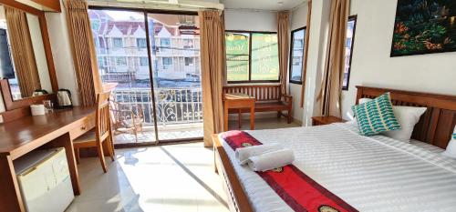 a bedroom with a bed and a large window at Royal Sweet Hotel in Patong Beach