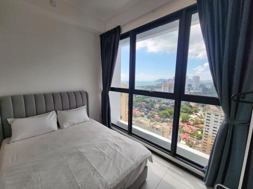 Executive Urban Suites - George Town @ Penang في Jelutong: غرفة نوم بسرير ونافذة كبيرة