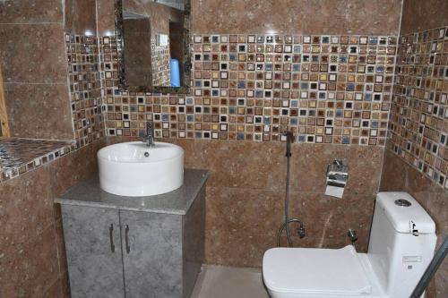 uma casa de banho com um lavatório e um WC em Orchard Oasis Home Stay em Mukteshwar