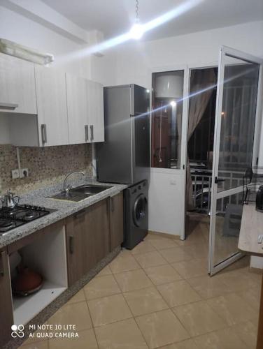 a kitchen with a sink and a washing machine in it at Appartement moderne F3 tout neuf in Marrakech