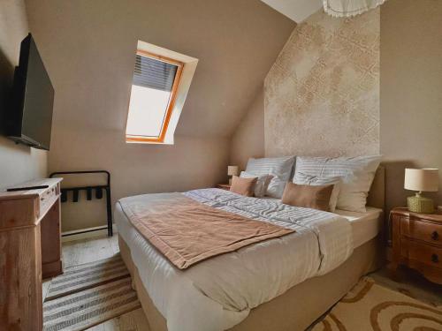 Un dormitorio con una cama grande y una ventana en Herczeg-Fekete Cottage Birtokközpont, en Simontornya