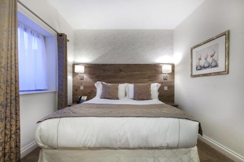 a bedroom with a large bed and a window at Hotel Shepherds Bush London in London