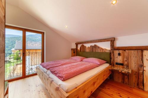 a bedroom with a bed and a large window at Huberhof in Villandro