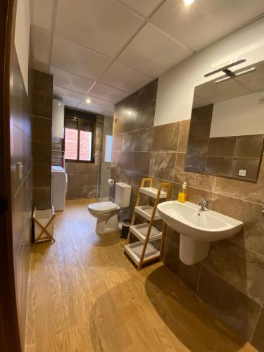 a bathroom with a sink and a toilet and a mirror at Apartamentos El Valle in Riópar