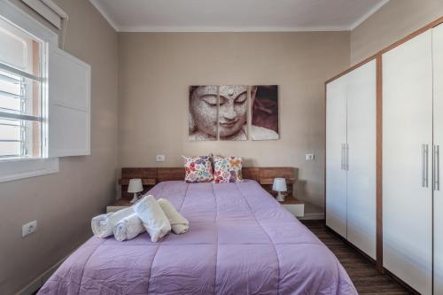 a bedroom with a purple bed and a statue at Branmi House Barranco Grande in Santa Cruz de Tenerife