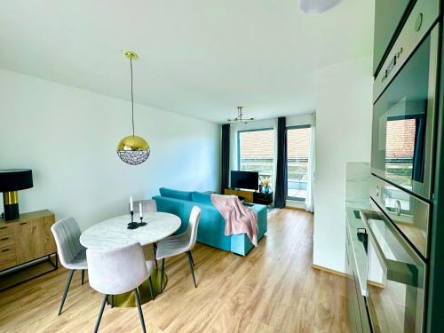 uma sala de estar com uma mesa e um sofá azul em Central Apartment Budapest ~ Roof Terrace/AC/Indoor parking em Budapeste