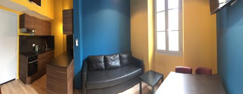 sala de estar con silla de cuero y mesa en Appartements Nice Centre Carré d’or, en Niza