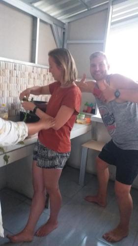 a man and a woman standing in a kitchen at The Daun Puntik HomeStay in Pawenang